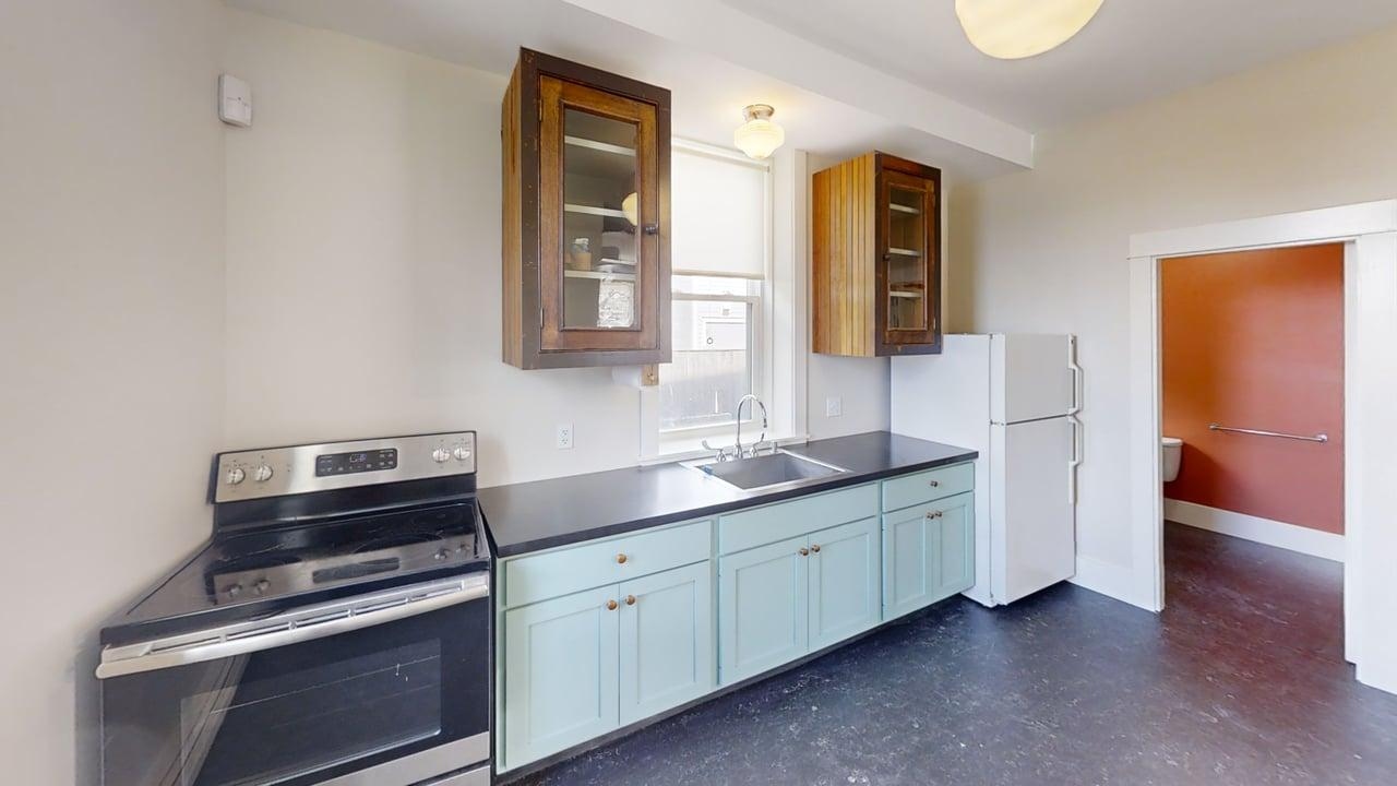 Full kitchen with range, refrigerator, and mint cabinetry